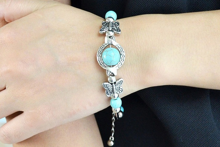 Feminint armbånd med sommerfuglevedhæng og sølv- og turkisfarvede perler 1 